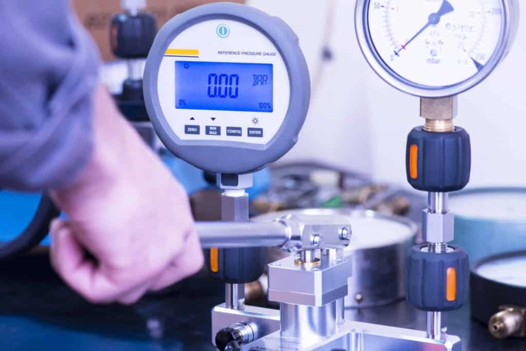 Técnico ES Engenharia realizando calibração de manômetro industrial com padrão rastreável ao INMETRO — NR-13